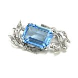 A 9CT WHITE GOLD AND LARGE EMERALD CUT TOPAZ BROOCH OF ORGANIC DESIGN. (3.7cm x 2cm)