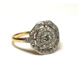 AN ART DECO YELLOW METAL AND DIAMOND CLUSTER RING The central round cut diamond with two rows of