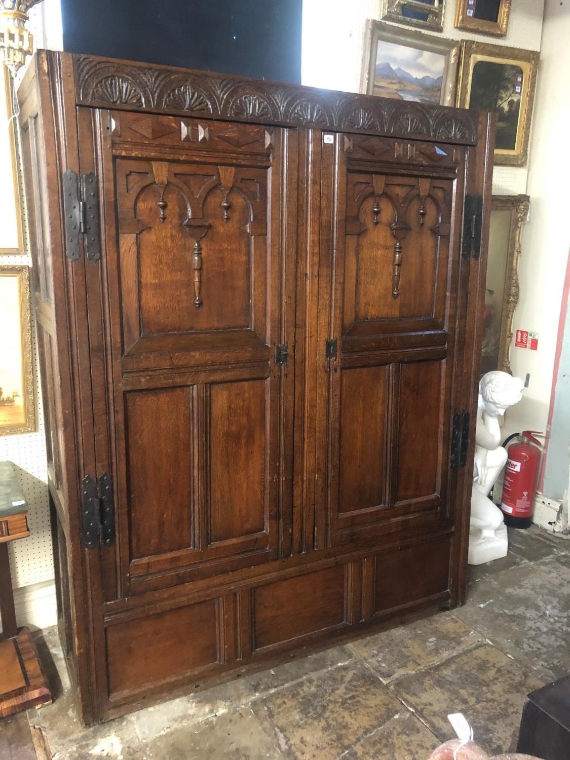 AN ANTIQUE OAK CUPBOARD With carved arcaded frieze above two panelled doors applied with - Image 2 of 4