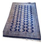 A LARGE BOKHARA WOLLEN RUG Having geometric design to field on dark blue ground with running