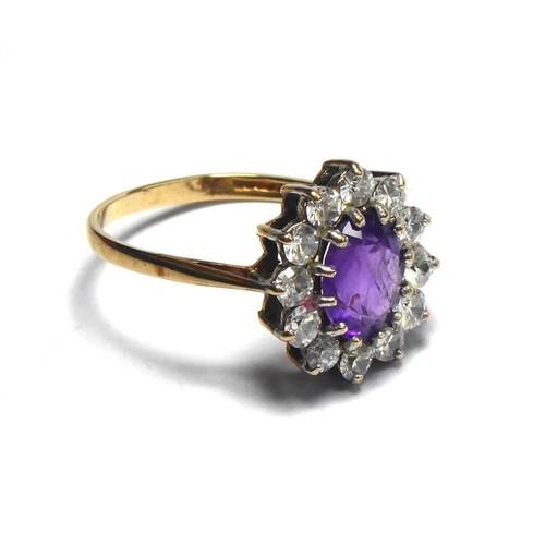 A 9CT GOLD AMETHYST AND PASTE RING The oval cut amethyst edged in paste stones. (size O/P)