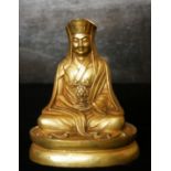 A CHINESE/TIBETAN GILT BRONZE BUDDHA Seated pose with geometric form headdress and holding a flaming