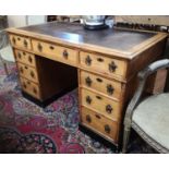 A VICTORIAN OAK TWIN PEDESTAL DESK With a black tooled leather top above an arrangement of nine