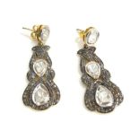 A PAIR OF CONTINENTAL SILVER GILT AND DIAMOND DROP EARRINGS Having three rough cut diamonds in a