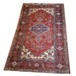 A PERSIAN WOOLLEN RUG Having geometric design to central field with wide running border on dark