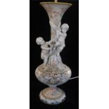 AN EARLY 20TH CENTURY ITALIAN VASE DECORATED WITH PUTTI AND FACIAL MASKS AMONGST FLORA CONVERTED