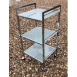 A CHROME DRINK'S TROLLEY With three tempered glass shelves. (39cm x 36cm x 81cm)