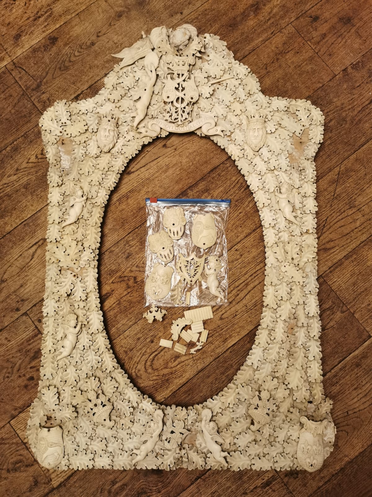 A 19TH CENTURY FRENCH DIEPPE IVORY PICTURE FRAME Heavily applied with coats of arms cherubs