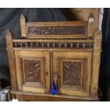 AN EDWARDIAN TABLETOP/ WALL MOUNTING OAK CABINET With turned gallery rail and two panelled doors