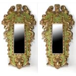 A PAIR OF VENETIAN SHIELD SHAPED MIRRORS The green painted and parcel gilt gesso frames carved