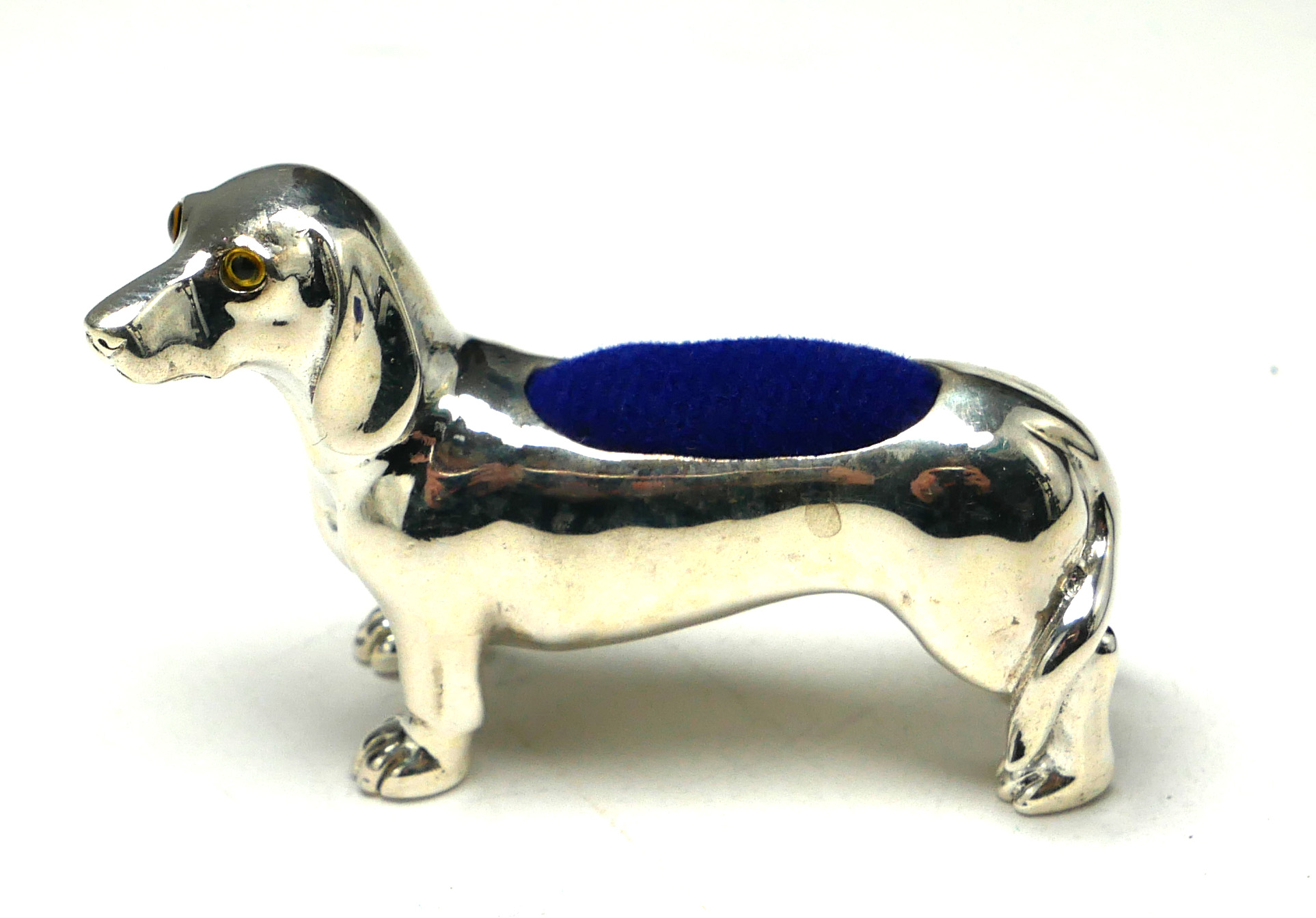 A STERLING SILVER NOVELTY 'DASCHHOUND' PIN CUSHION Standing pose with blue velvet cushion. (approx