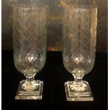 A PAIR OF CUT GLASS STORM LANTERNS On square stepped platform bases. (40cm) Condition: good