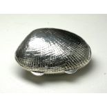 A SILVER 'CLAM SHELL' NOVELTY PILL BOX Having fine textured engraving. (approx 4cm)