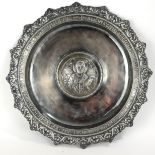 A RUSSIAN ORTHODOX WHITE METAL ECCLESIASTICAL PATEN/CHARGER Having a scrolled border with
