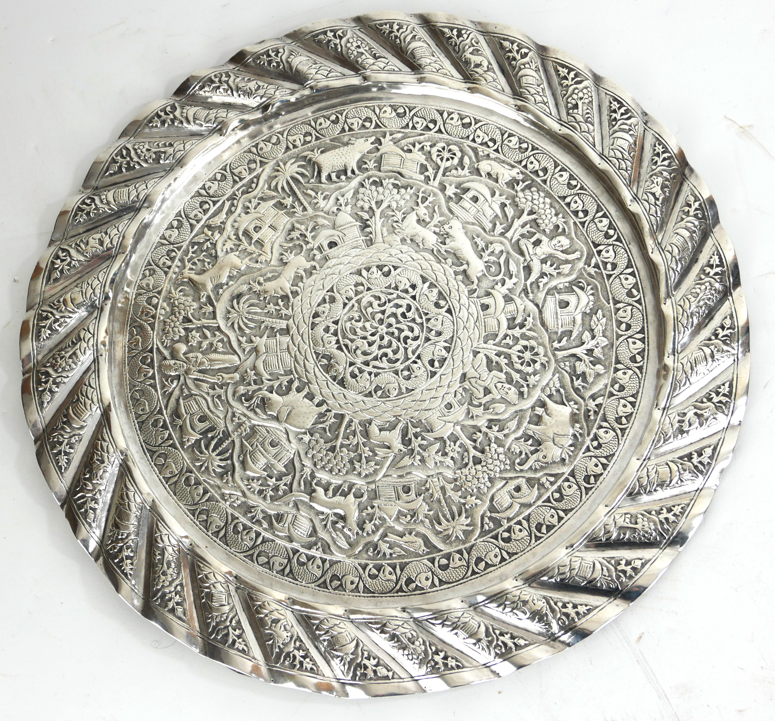 AN INDIAN SILVER SALVER Having a fine chased engraving of a continuous landscape with animals and