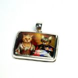 A SILVER AND ENAMEL NOVELTY RECTANGULAR CAT PENDANT Having two cars wearing Royal clothing. (