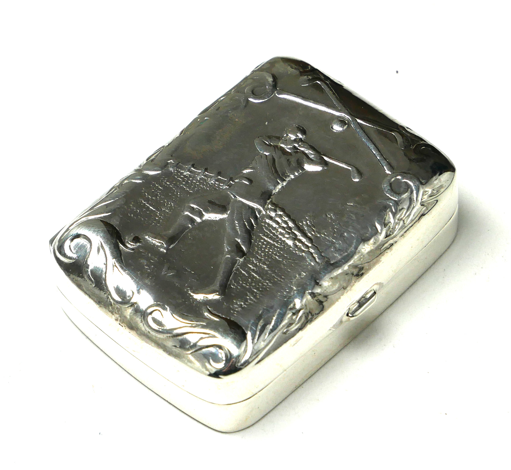 A STERLING SILVER NOVELTY'GOLF' PILL BOX Having a hinged lid with embossed golfing scene. (approx