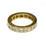 A YELLOW METAL AND DIAMOND ETERNITY RING Having a row of twenty-two Princess cut diamonds, with