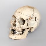 A LATE 19TH CENTURY HUMAN SKULL WITH SPRUNG JAW AND REMOVABLE TOP (h 16cm x w 22cm x d 13.5cm)