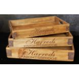 A SET OF THREE WOODEN GRADUATED HARRODS ADVERTISING TRAYS With metal bound corners. (largest 56cm