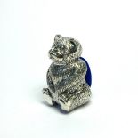 A SILVER TEDDY BEAR FORM NOVELTY PIN CUSHION Standing pose with blue velvet cushion. (approx 3cm)