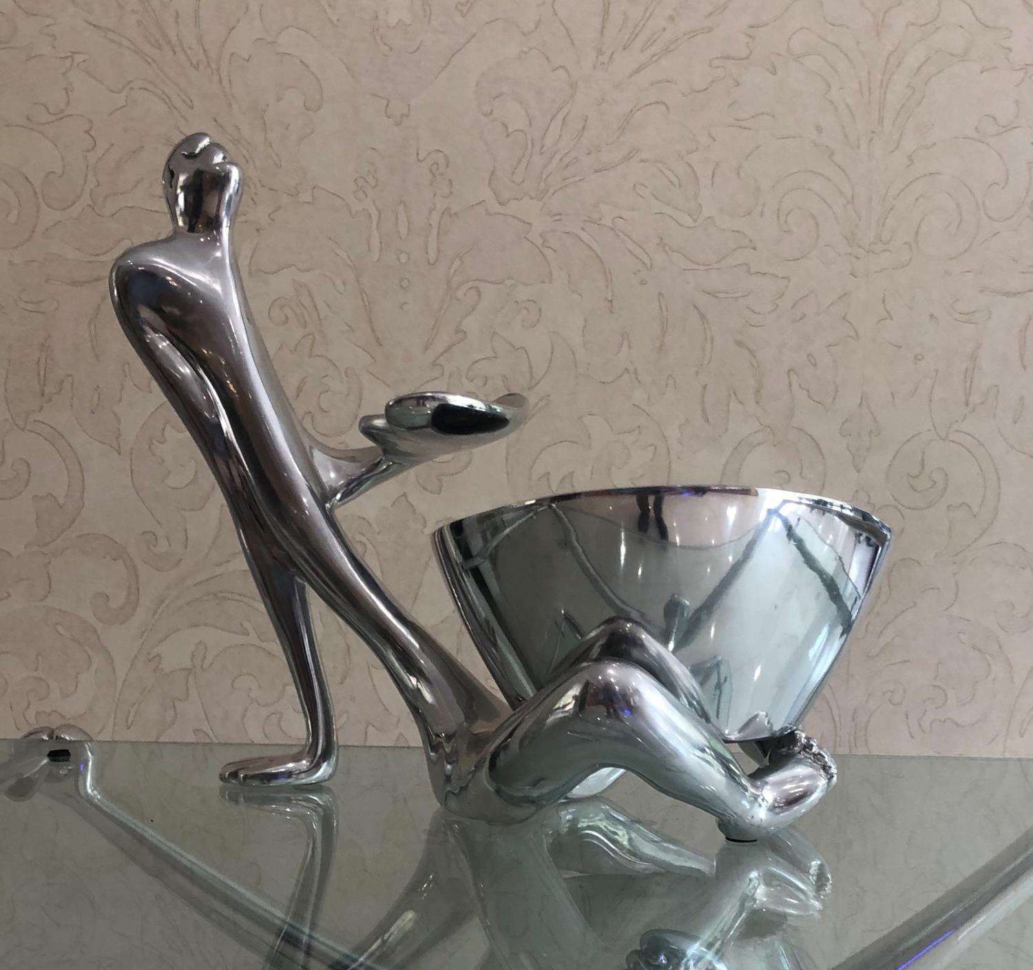 CARROL BOYES, AN ALUMINIUM TABLE CENTREPIECE Male figure with freestanding bowl resting between
