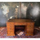 AN EDWARDIAN MAHOGANY PARTNER'S DESK With green tooled leather top above an arrangement of nine