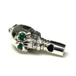 A STERLING SILVER 'SKULL' NOVELTY WHISTLE With green glass set eyes. (approx 3.5cm)