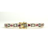A CONTINENTAL SILVER GILT AND DIAMOND RUBY BANGLE The row of rough cut diamonds interspersed with