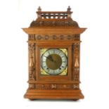A 19TH CENTURY GERMAN OAK MANTEL CLOCK Having a carved gallery to top and column supports, brass