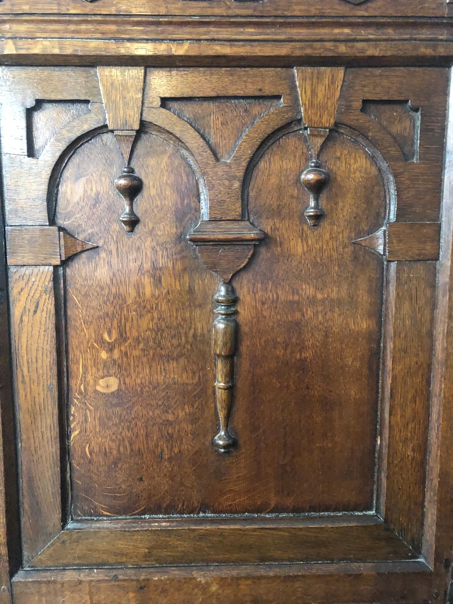 AN ANTIQUE OAK CUPBOARD With carved arcaded frieze above two panelled doors applied with - Image 4 of 4