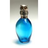 A WHITE METAL AND TURQOISE GLASS NOVELTY 'OWL' SCENT BOTTLE The hinged lid cast as an owl with glass