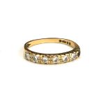 A 9CT GOLD AND DIAMOND HALF ETERNITY RING The single line of round cut stones (size L/M).