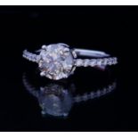 AN 18CT WHITE GOLD AND 1.8CT DIAMOND RING The brilliant round cut diamond edged with diamond