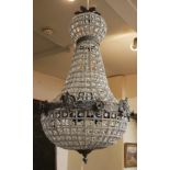 A CONTINENTAL PLANISHED METAL AND GLASS PRISM BASKET CHANDELIER Banded with facial masks and