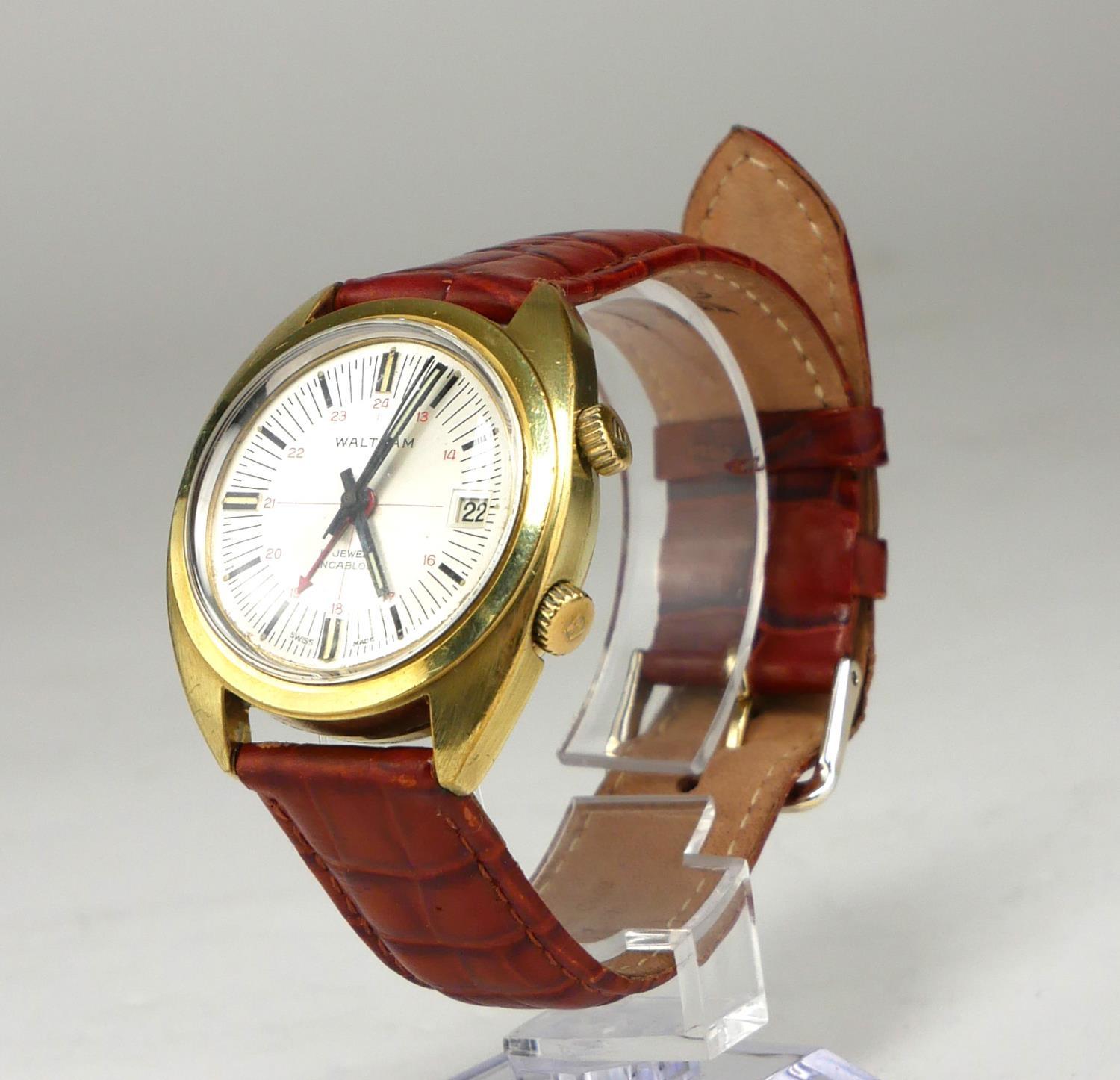 WALTHAM, A VINTAGE YELLOW METAL ALARM DATE WRISTWATCH On a brown leather faux crocodile skin