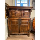 AN 18TH CENTURY OAK COURT CUPBOARD With four fielded panelled doors centred with a central sliding