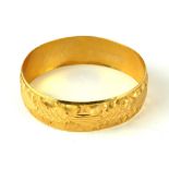 AN INDIAN 22CT GOLD BANGLE With engraved decoration, unmarked. (6.7cm)