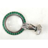 A SILVER AND PASTE SET 'HAND' NOVELTY MAGNIFYING GLASS Female hand with lace cuff and green glass