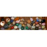 A COLLECTION OF POLISHED STONE EGGS Along with glass spheres.