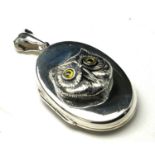 A SILVER 'OWL' NOVELTY PENDANT LOCKET Having an applied owl head with glass eyes and glass eyes. (