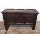 A 17TH CENTURY CARVED OAK THREE PANELLED COFFER With fitted candle box, on stile legs. (102cm x 43cm