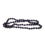 A CARVED AMETHYST BEAD NECKLACE Having a strand of spherical carved stone beads. (each bead approx