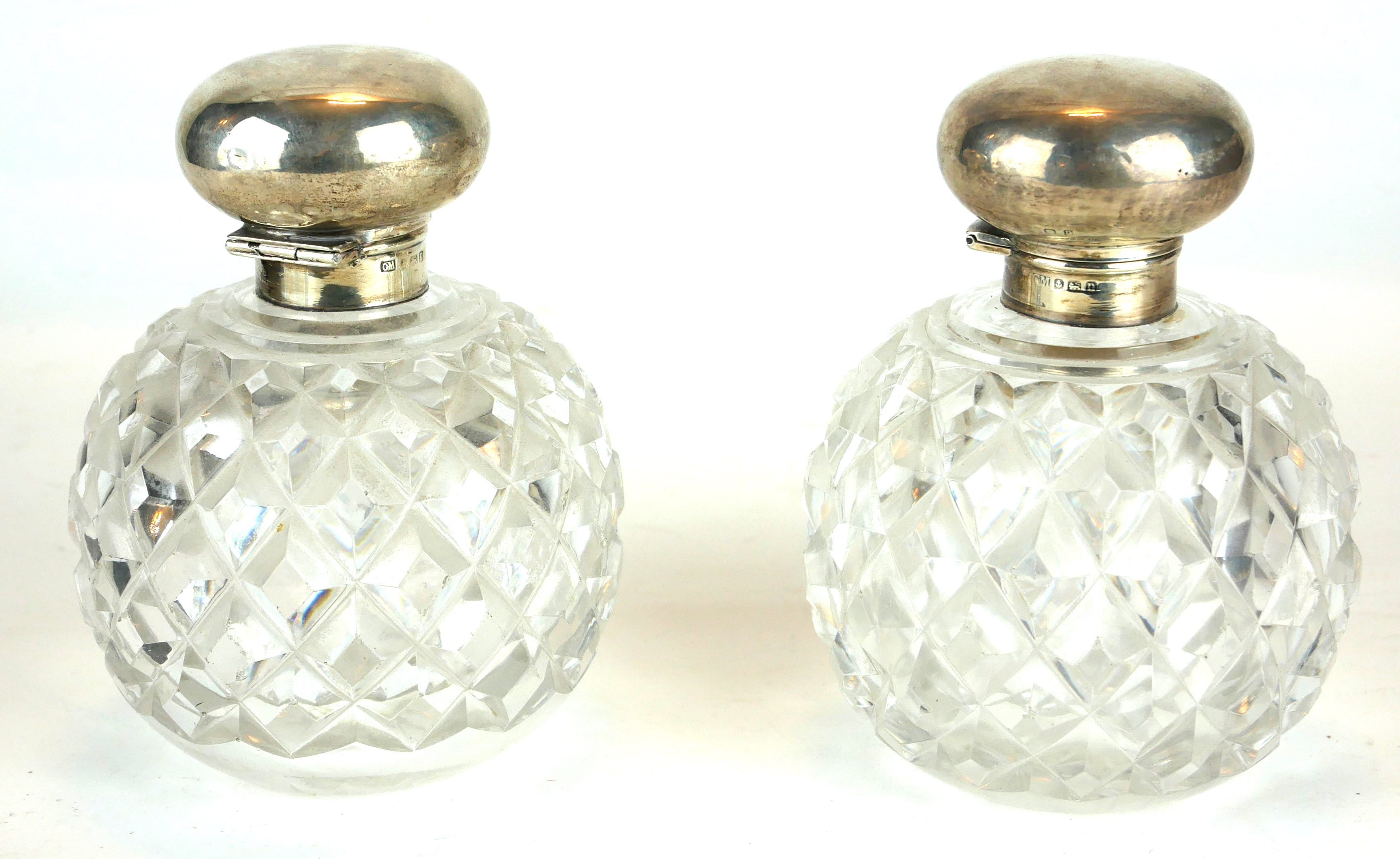 A PAIR OF EDWARDIAN SILVER AND HOBNAIL CUT GLASS PERFUME BOTTLES Spherical hinged lids, hallmarked