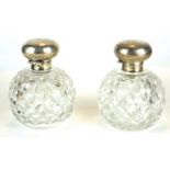 A PAIR OF EDWARDIAN SILVER AND HOBNAIL CUT GLASS PERFUME BOTTLES Spherical hinged lids, hallmarked