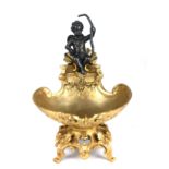 A REGENCY STYLE PATINATED AND GILT BRONZE SALT Figured with a cherub. (19cm) Condition: good