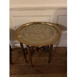 AN EARLY 20TH CENTURY ISLAMIC BRASS FOLDING CIRCULAR TABLE With Cyrilic inscription on folding