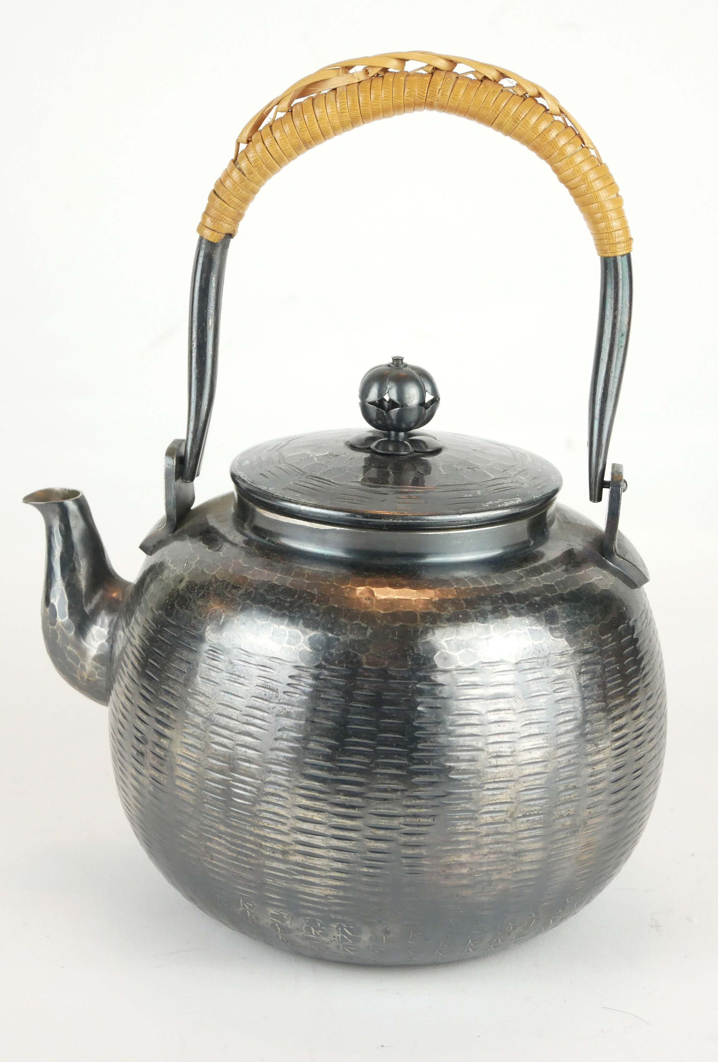 A JAPANESE WHITE METAL TEA KETTLE Having cane handle and matt finish textured body, bearing a four