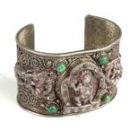 A TIBETAN BLIND FILIGREE SILVER BANGLE Decorated with figures of Gods and serpents, inset with