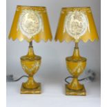 A PAIR OF REGENCY STYLE TOLEWARE TABLE LAMPS AND SHADES Decorated with urns and swags on a mustard